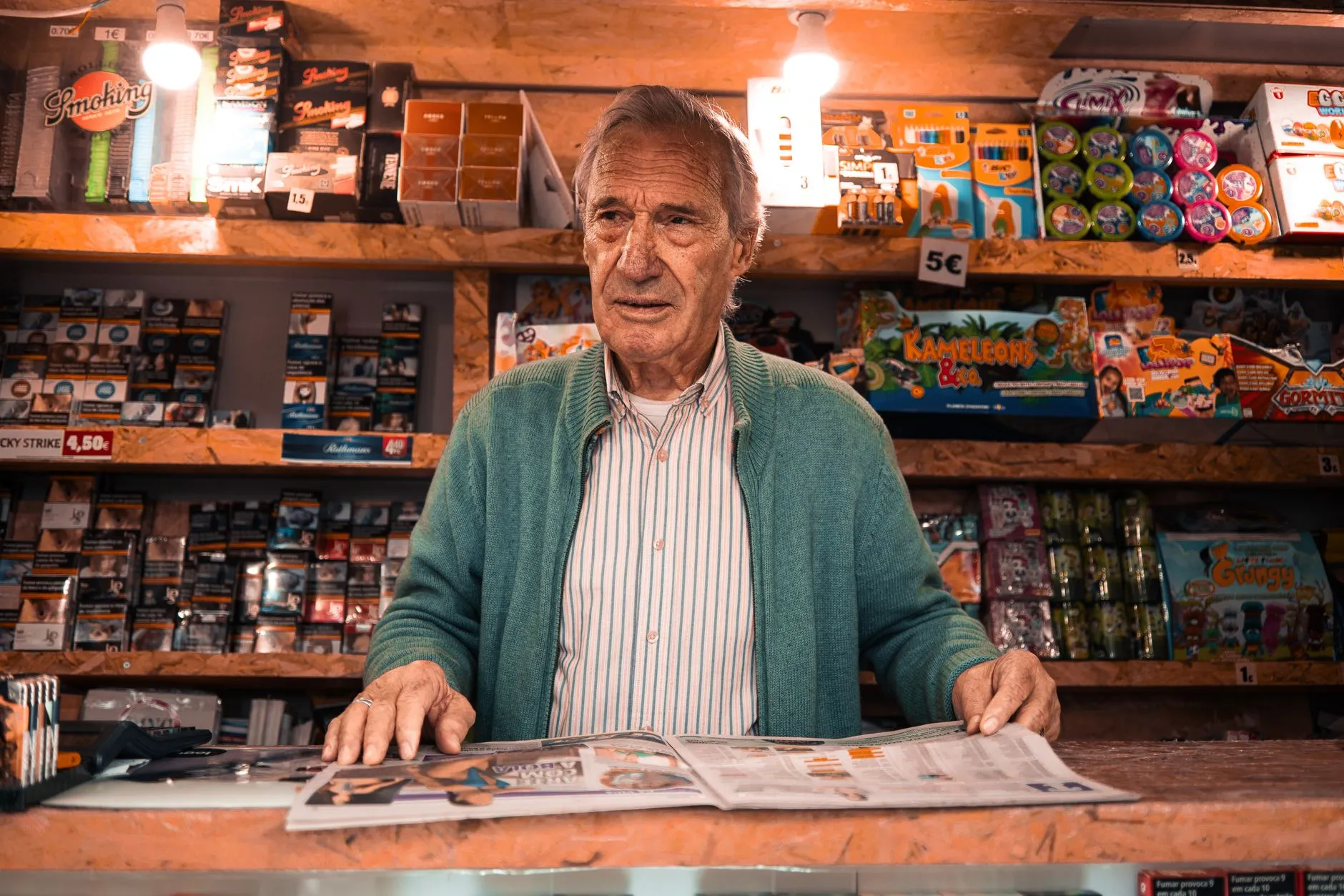 Comerciante mayor leyendo tras el mostrador de su tienda