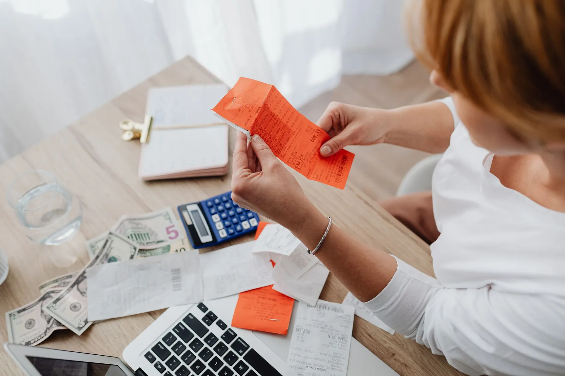 Autónoma revisando facturas y tiques con la calculadora junto al portátil