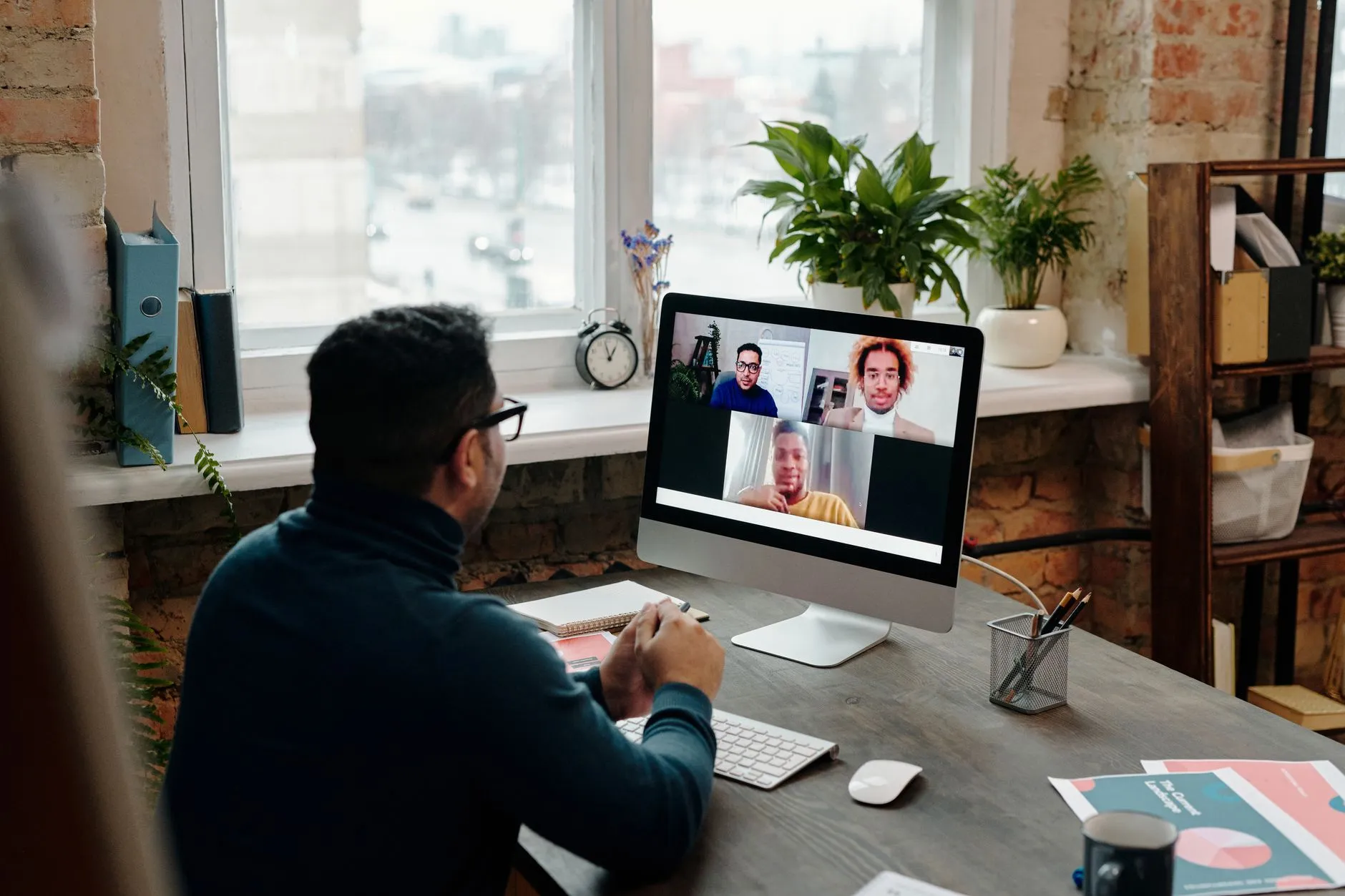 Profesional en una videollamada con su equipo desde la oficina